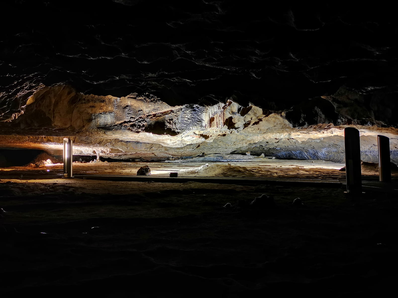 Grande salle de la grotte de Gargas éclairée par des bornes lumineuses, révélant les parois et la voûte calcaires (photo G. Pujol / CCNB)